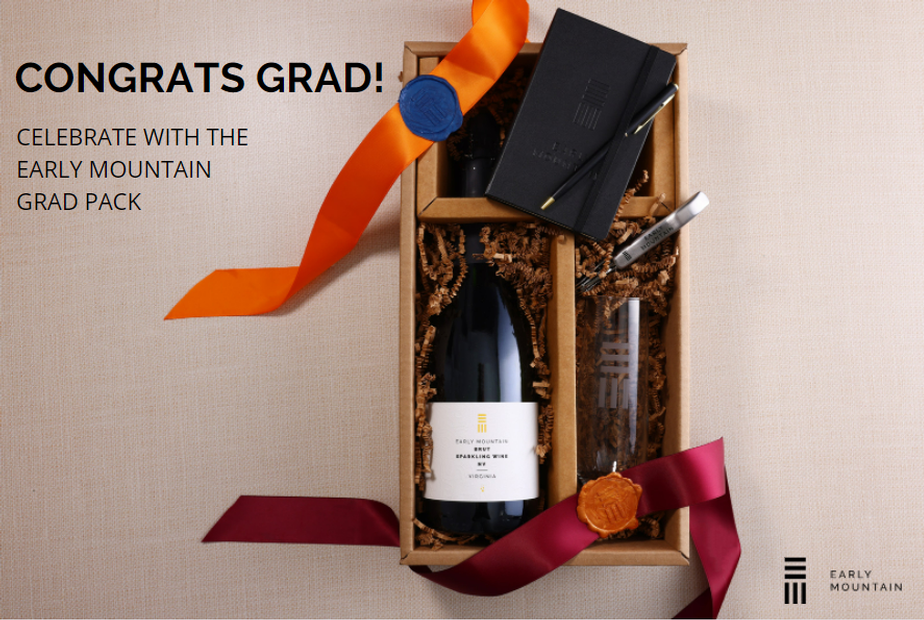 The Grad Pack - Click to view our Grad Pack gift option (image shows a gift box with a bottle of sparkling wine, champagne flute, ribbon, notebook, and pen))