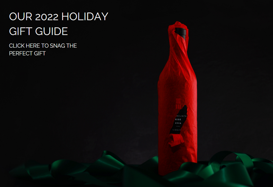 A bottle of 2019 RISE, wrapped in red tissue paper, surrounded by green ribbon, with 